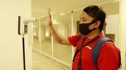 Seorang wartawan melakukan pengecekan suhu tubuh sebelum memasuki Stadion Madya untuk meliput pertandingan antara Timnas Indonesia melawan Persikabo 1973. (Bola.com/ M Iqbal Ichsan)