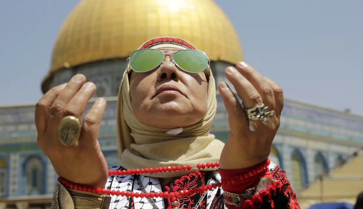 Seorang wanita Palestina berdoa di depan Kubah Shakhrah yang berada di tengah kompleks Masjid Al Aqsa, Yerusalem (8/6). Mereka memanfaatkan hari Jumat terakhir di bulan Ramadan untuk berdoa dan salat berjemaah di Masjid Al Aqsa. (AP/Mahmoud Illean)