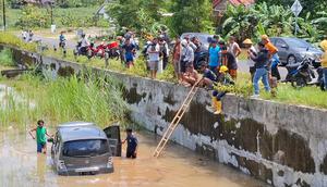 Warga bergotong-royong mengevakuasi mobil yang masuk ke area persawahan karena sopir mengantuk. (Liputan6.com/ Hendro Ary Wibowo)