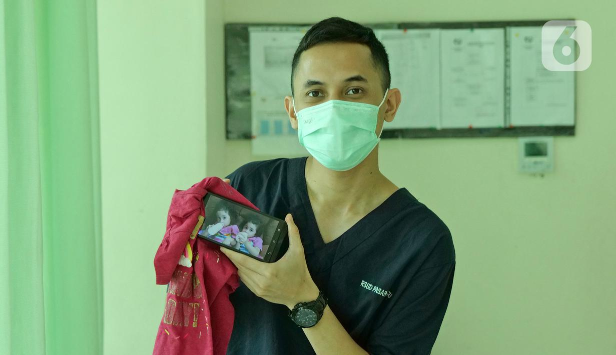 dr. Kevin William Hutomo (29) menunjukkan foto anaknya saat di RSUD Pasar Minggu, Jakarta, Jumat (22/5/2020). Kevin William Hutomo sudah 2 bulan tidak bertemu keluarga selama bertugas menjaga COVID -19 di RSUD Pasar Minggu. (Liputan6.com/Herman Zakharia)