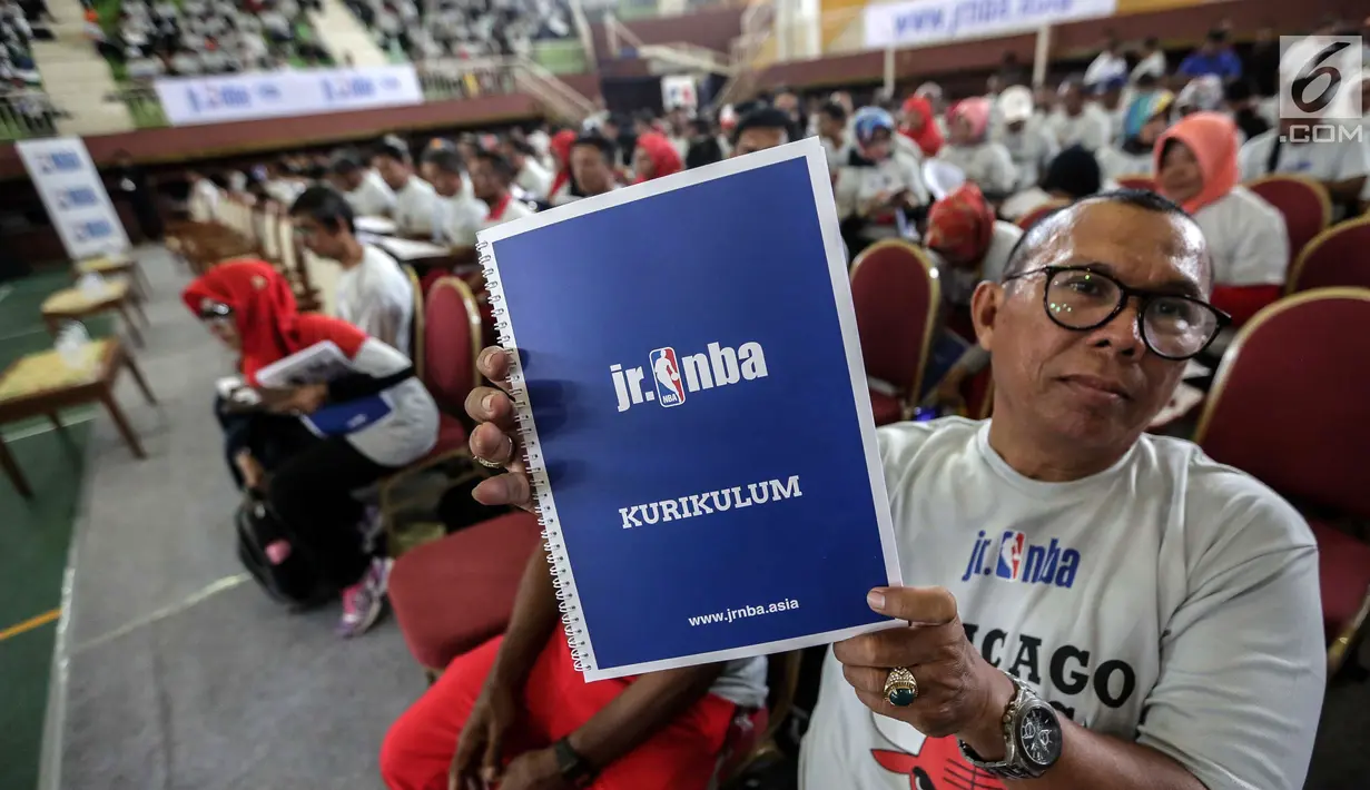 Seorang guru olahraga menunjukkan buku kurikulum pelatihan pendidikan basket dari Akademi Pelatih Junior NBA di GOR Ciracas, Jakarta, Rabu (24/1). Pendidikan ini ditujukan kepada lebih dari lima ribu guru olahraga di Jakarta. (Liputan6.com/Faizal Fanani)