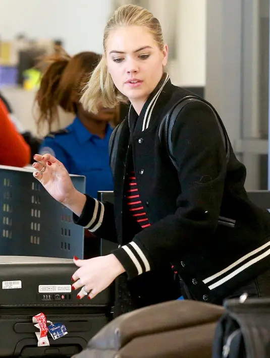 Kate Upton mengawasi kopernya saat melakukan security check di bandara Los Ageles. (Backgrid/USWeekly)