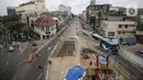 Transjakarta melintas dekat lokasi ditemukannya rel trem di lokasi pembangunan MRT Jakarta fase 2, Glodok, Jakarta, Selasa (28/12/2021). Rel trem itu ditemukan di bawah jalur TransJakarta di Jalan Pintu Besar Selatan pada Desember 2021. (Liputan6.com/Faizal Fanani)
