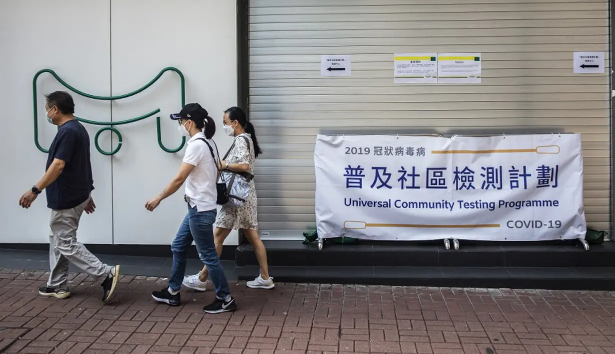 Sejumlah orang berjalan melewati pusat pengujian virus corona COVID-19 di Hong Kong, Selasa (1/9/2020). Hong Kong mulai melakukan tes massal virus corona COVID-19. (ISAAC LAWRENCE/AFP)