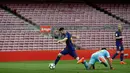 Pemain Barcelona, Lionel Messi berhasil melewati kiper Las Palmas sebelum mencetak gol kedua pada pertandingan Liga Spanyol di Camp Nou, Senin (2/10) dini hari. Dua gol Messi mewarnai kemenangan Barcelona3-0. (AP/Manu Fernandez)