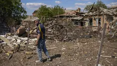 Seorang penduduk setempat berdiri di samping sebuah rumah yang hancur dalam pemboman Rusia di Bakhmut, Ukraina timur, Selasa (24/5/2022). Kota Bakhmut telah mengalami peningkatan serangan artileri, terutama selama seminggu terakhir, ketika pasukan Rusia mencoba untuk terus maju mengepung kota Sieverodonetsk di timur laut. (AP Photo/Francisco Seco)