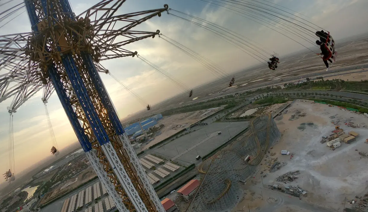 Pengunjung menaiki wahana ontang-anting Sky Flyer atau di Taman Bollywood, Dubai, Uni Emirat Arab (18/2/2021).  Bollywood Parks Dubai sempat ditutup selama beberapa bulan karena pandemi Covid-19. (AFP/ Giuseppe Cacae)