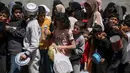 Mereka membawa piring dan wadah seadanya untuk menampung makanan gratis yang disediakan oleh dapur umum tersebut. (Eyad BABA/AFP)