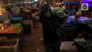 Seorang pria membawa sayuran di pundaknya di Pasar Induk Kramat Jati, Jakarta, Kamis (29/12/2022). Rencananya, revitalisasi Pasar Kramat Jati ini akan selesai sekitar 18 bulan. (Liputan6.com/Faizal Fanani)