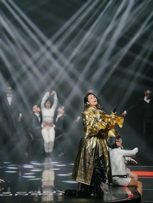 Di atas panggung, Anggun C. Sasmi tampil ekstra glamor dengan jubah metalik warna emasnya. [Foto: IG/anggun_cipta]