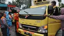 Petugas mengevakuasi truk boks yang rusak parah akibat tertimpa pohon tumbang di Jalan Padjajaran, Kota Tangerang Selatan, Banten, Sabtu (5/3/2022). Pengendara yang terluka karena tertimpa pohon tumbang dibawa ke RSUD Tangerang Selatan. (merdeka.com/Arie Basuki)