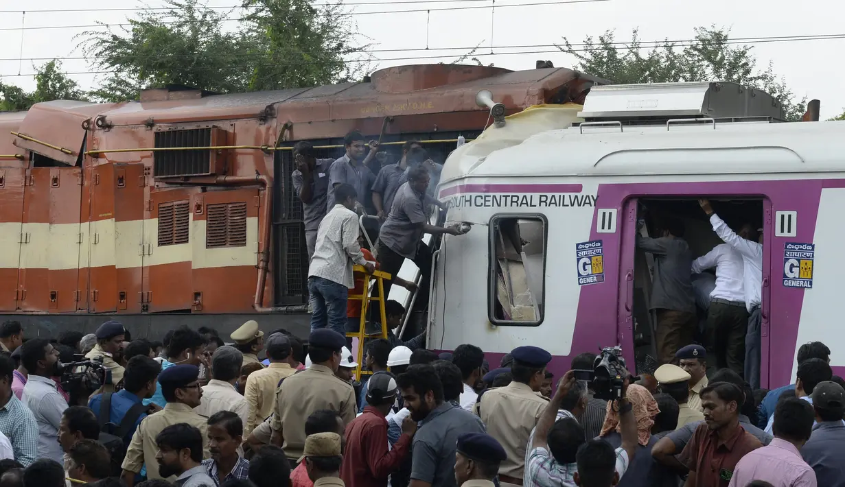 Petugas berusaha menyelematkan seorang pekerja di kabin kereta api surburban setelah bertabrakan dengan kereta ekspres antarkota di Stasiun Kereta Api Kachiguda di Hyderabad, India (11/9/2019). Sekitar 12 orang terluka akibat kecelakaan tersebut. (AFP Photo/Noah Seelam)