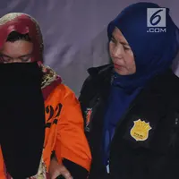 Tersangka kasus penipuan calon jemaah umroh, Kiki Hasibuan menunduk saat diperlihatkan polisi di Bareskrim Mabes Polri, Jakarta, Selasa (22/8). Hingga kini, polisi telah menetapkan tiga tersangka kasus tersebut. (Liputan6.com/Helmi Fithriansyah)