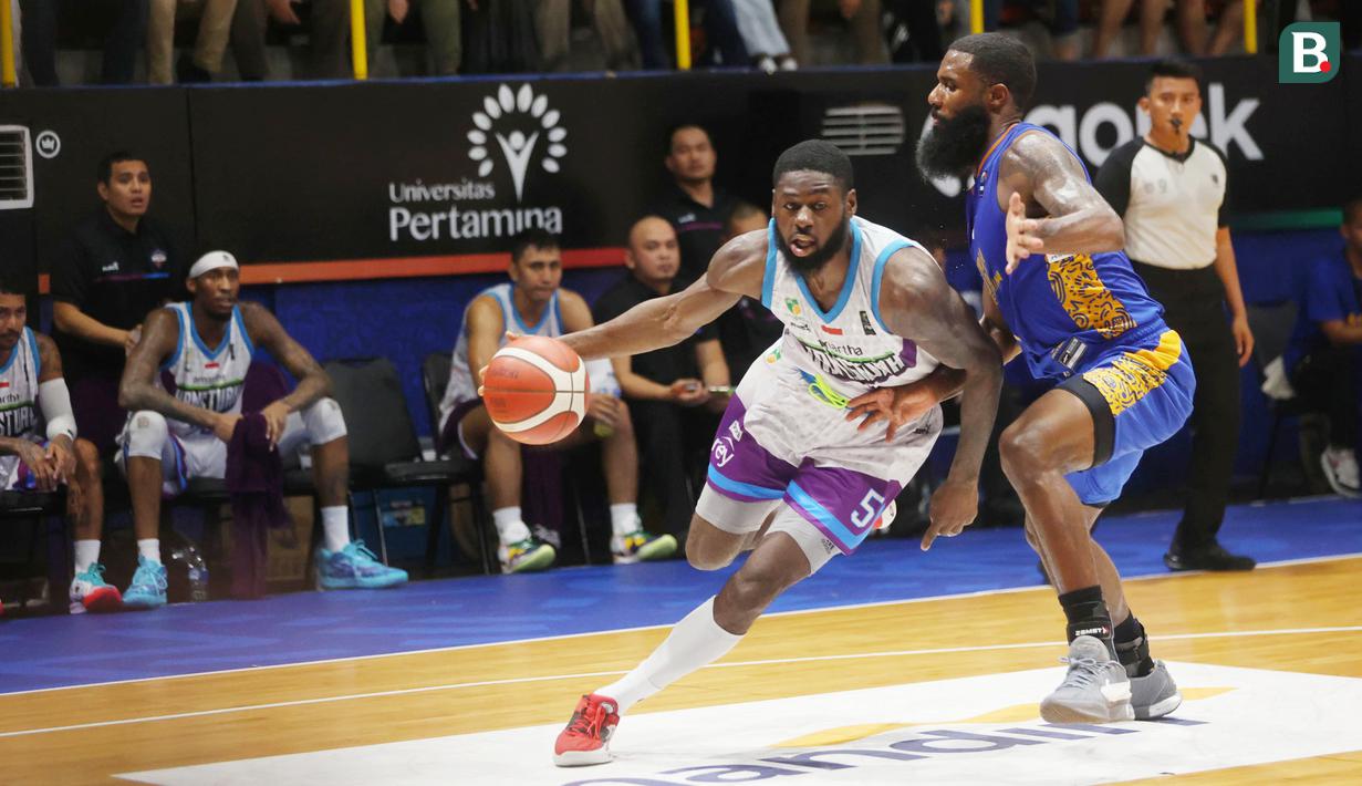 Pebasket Amartha Hangtuah, Michael Ayodele Kolawole, berusaha melewati pebasket Satria Muda Pertamina, Reynaldo Garcia Zamora, pada laga lanjutan musim reguler IBL 2024 di Pertamina Simprug Arena,  Jumat (24/5/2024). (Bola.com/M iqbal Ichsan)