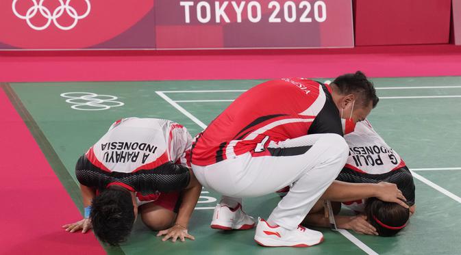 Ganda putri Indonesia Greysia Polii dan Apriyani Rahayu berselebrasi dengan pelatih mereka Eng Hian setelah mengalahkan pasangan China Cheng Qingchen dan Jia Yi pada final badminton ganda putri Olimpiade Tokyo 2020 di Musashino Forest Sport, Senin (2/8/2021). (AP/Dita Alangkara)