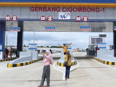 Beberapa warga berfoto berlatar gerbang tol Cigombong I di Cigombong, Kab Bogor, Jawa Barat, usai diresmikan, Sabtu (1/12). Ruas panjang tol Ciawi-Sukabumi Seksi I Ciawi-Cigombong sejauh 15,3 kilometer. (Liputan6.com/Helmi Fithriansyah)
