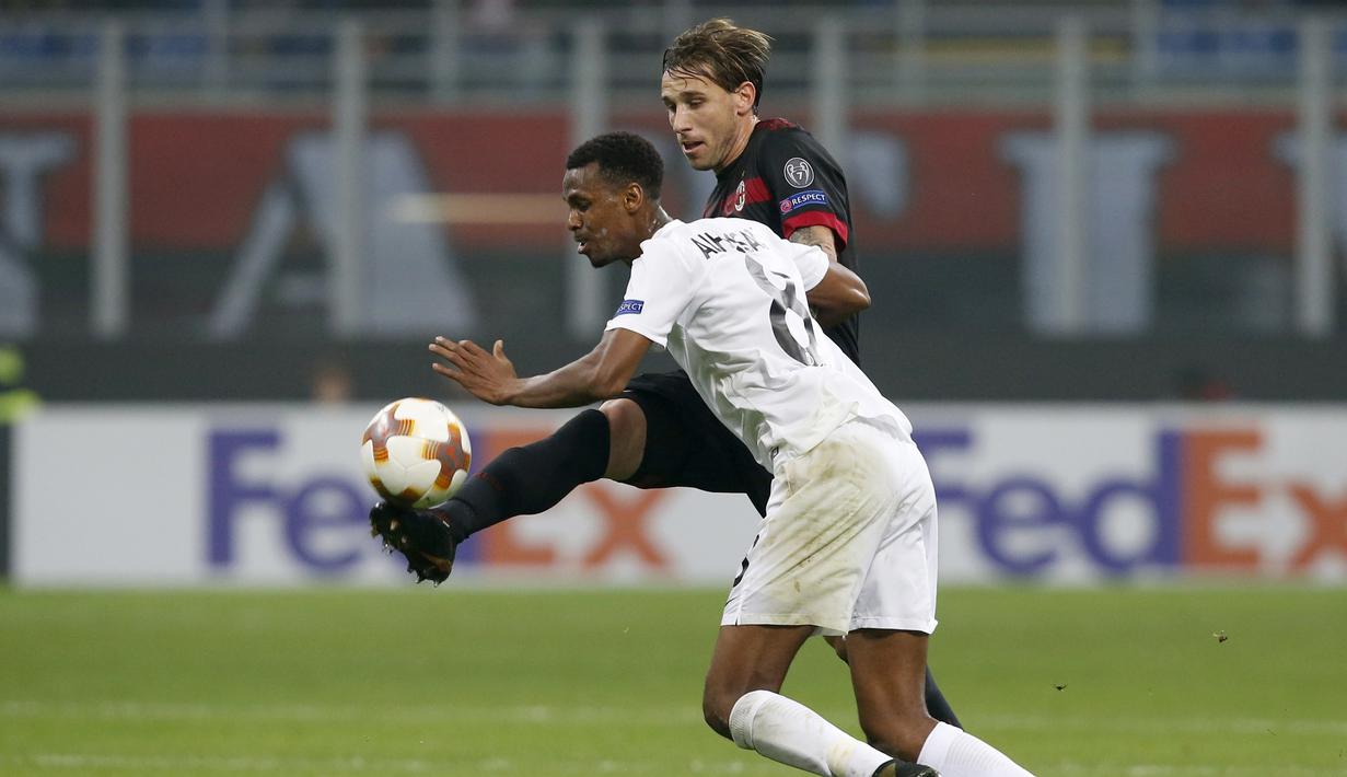 Aksi pemain AC Milan, Lucas Biglia (kanan) menghalau bola dari pemain Austria Wien, Abdullahi Ibrahim Alhassan pada laga grup D Liga Europa di San Siro stadium, Milan, (23/11/2017). Milan menang telak 5-1. (AP/Antonio Calanni)