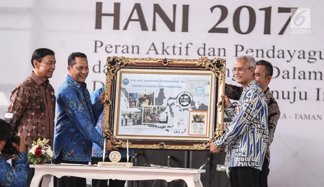 Kepala BNN, Komjen Pol Budi Waseso bersama Menko Polhukam Wiranto memberikan prangko edisi HANI 2017 dalam peringatan HANI di Plaza Tugu Api Pancasila, Taman Mini Indonesia Indah, Jakarta, Kamis (13/7). (Liputan6.com/Faizal Fanani)