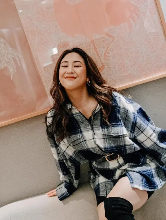 Sherina Munaf memadukan oversized flanel top bernuansa biru dengan legging hitam pendek dan high boots hitam. [Foto: Instagram/sherinamunaf]