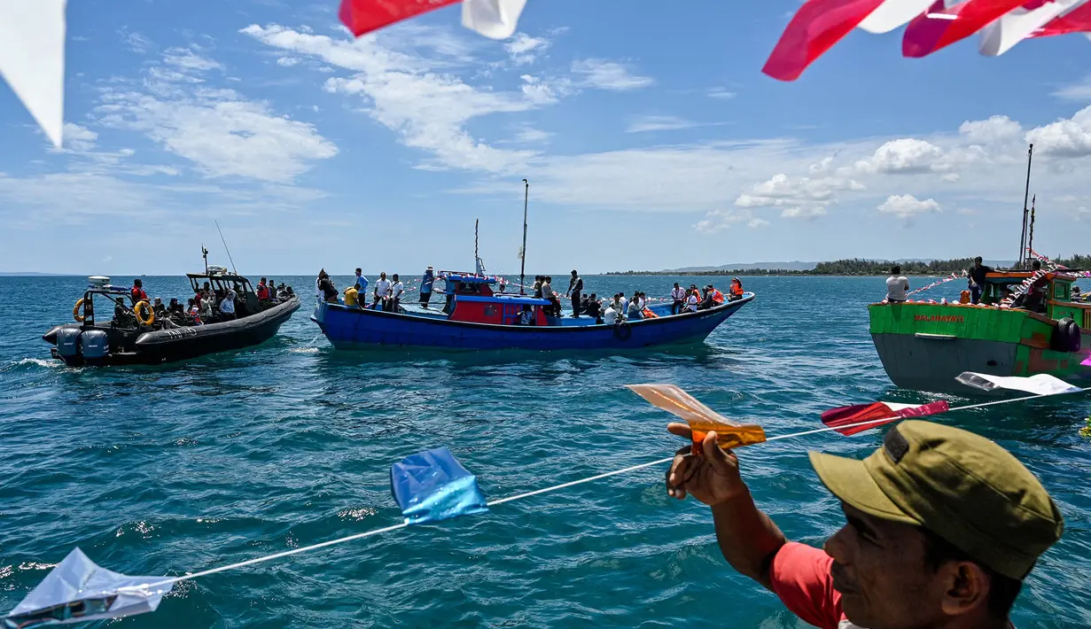 Indonesian fishermen take part in the traditional festival known as "Kenduri Laot," a maritime feast held as an expression of gratitude for the ocean, off the coast of Banda Aceh on July 22, 2026. (Photo by CHAIDEER MAHYUDDIN / AFP)
