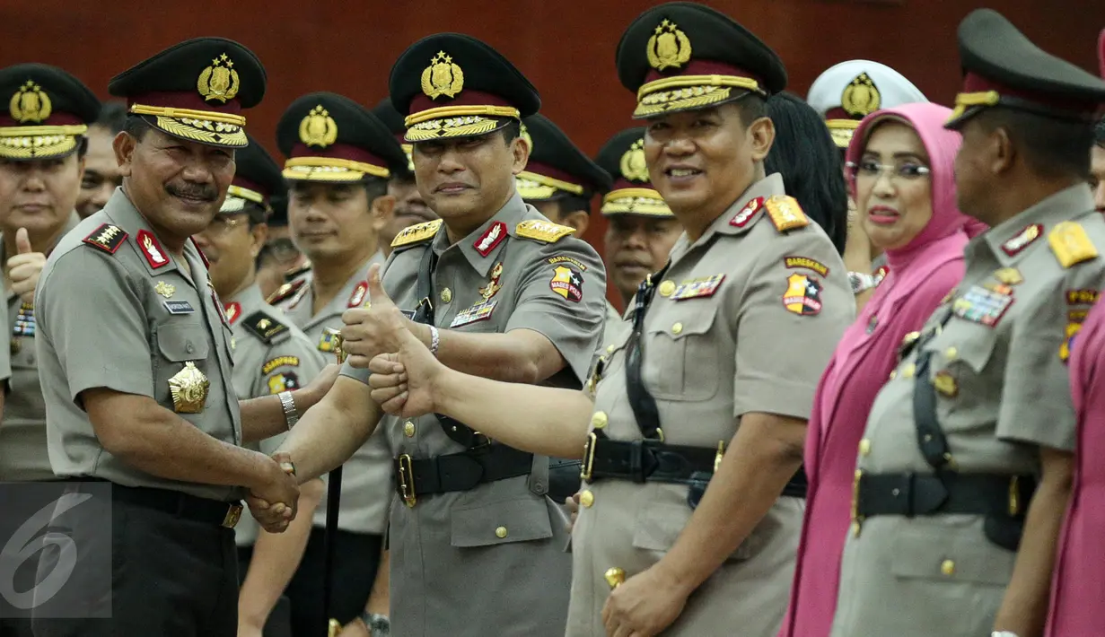 Kapolri Jenderal (Pol) Badrodin Haiti (kiri) berjabat tangan dengan Komjen Pol Budi Waseso (kedua kiri) ditemani Komjen Pol Anang Iskandar usai upacara serah-terima jabatan di Aula Rupatama Mabes Polri, Jakarta, Senin (7/9). (Liputan6.com/Faizal Fanani)