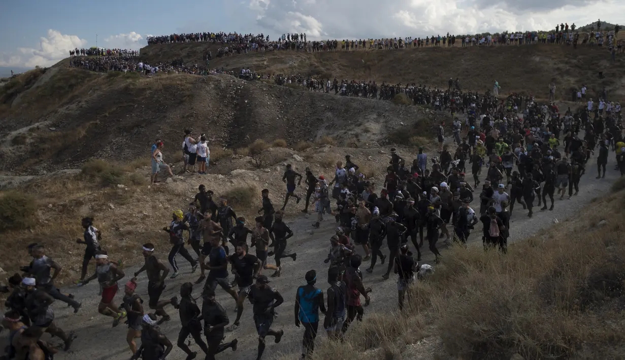 Para peserta dengan tubuh dilumuri minyak hitam mengikuti Festival Tradisionlal Cascamorras di Baza, Granada, Spanyol (6/9/2019). Festival Cascamorras merupakan tradisi warga Spanyol yang sudah dirayakan sejak 500 tahun lalu. (AFP Photo/Jorge Guerrero)