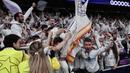 Penyerang Real Madrid, Brahim Diaz melompat ke tribun penonton setelah mencetak gol kedua bagi timnya pada pertandingan leg pertama 16 besar Liga Champions 2024/2025 melawan Atletico de Madrid di stadion Santiago Bernabeu, Madrid, pada 4 Maret 2025 waktu setempat atau Rabu (5/3/2025) dini hari WIB. (Thomas COEX/AFP)