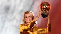 Bintang Lyon dan timnas Norwegia, Ada Hegerberg mengangkat trofi setelah memenangkan penghargaan Ballon d'Or perempuan 2018 di Paris, Senin (3/12). Hegerberg adalah salah satu dari tujuh pemain dari tim Lyon masuk di antara 15 nominasi. (FRANCK FIFE/AFP)