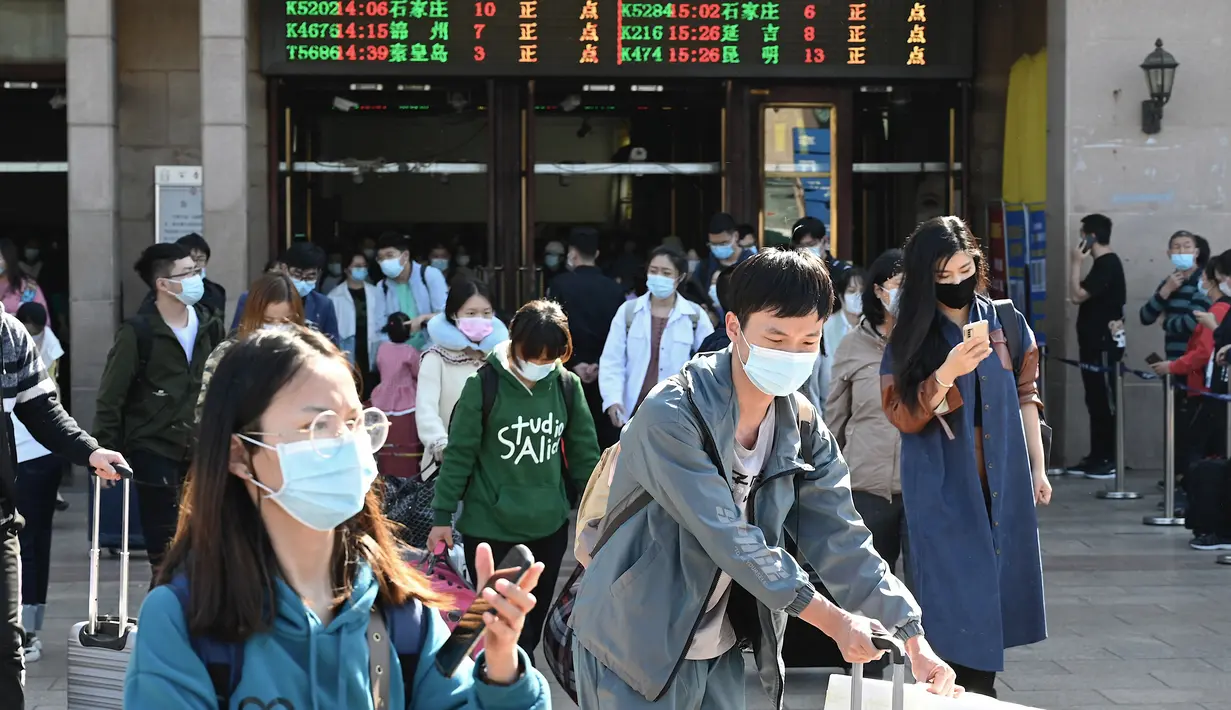 Orang-orang tiba di stasiun kereta api Beijing pada hari terakhir libur nasional "golden week", Kamis (7/10/2021). Liburan yang kerap disebut sebagai The Golden Week Holiday ini adalah peringatan berdirinya Republik Rakyat China pada tahun 1949. (JADE GAO / AFP)
