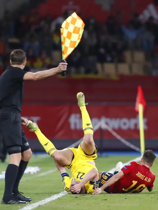 Pemain Swedia Dejan Kulusevski (tengah) dan pemain Spanyol Jordi Alba terjatuh pada pertandingan sepak bola kualifikasi Grup B Piala Dunia 2022 di Stadion La Cartuja, Seville, Spanyol, 14 November 2021. Spanyol menang 1-0. (AP Photo/Angel Fernandez)