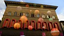 Sebanyak 22 perahu karet berwarna oranye digantungkan di dekat jendela istana dari Strozzi Palace, Italia, Rabu (21/9). Karya seni instalasi seniman fenomenal asal Tiongkok Ai Weiwei itu berjudul “Reframe”. (GABRIEL BOUYS/AFP)