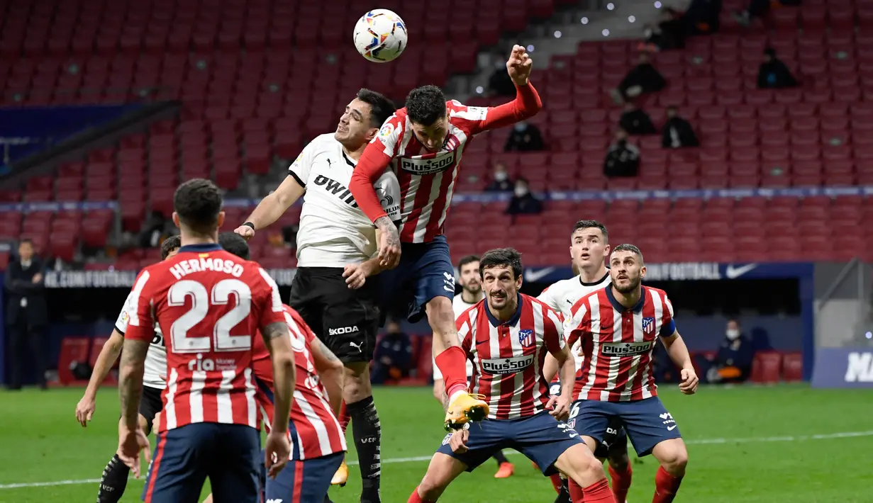 Penyerang Valencia, Maxi Gomez (atas kiri) bersaing dengan bek Atletico Madrid, Jose Gimenez pada jornada ke-20 Liga Spanyol di Wanda Metropolitano, Senin (25/1/2021) dini hari WIB. Atletico Madrid memetik kemenangan 3-1 atas Valencia. (PIERRE-PHILIPPE MARCOU/AFP)