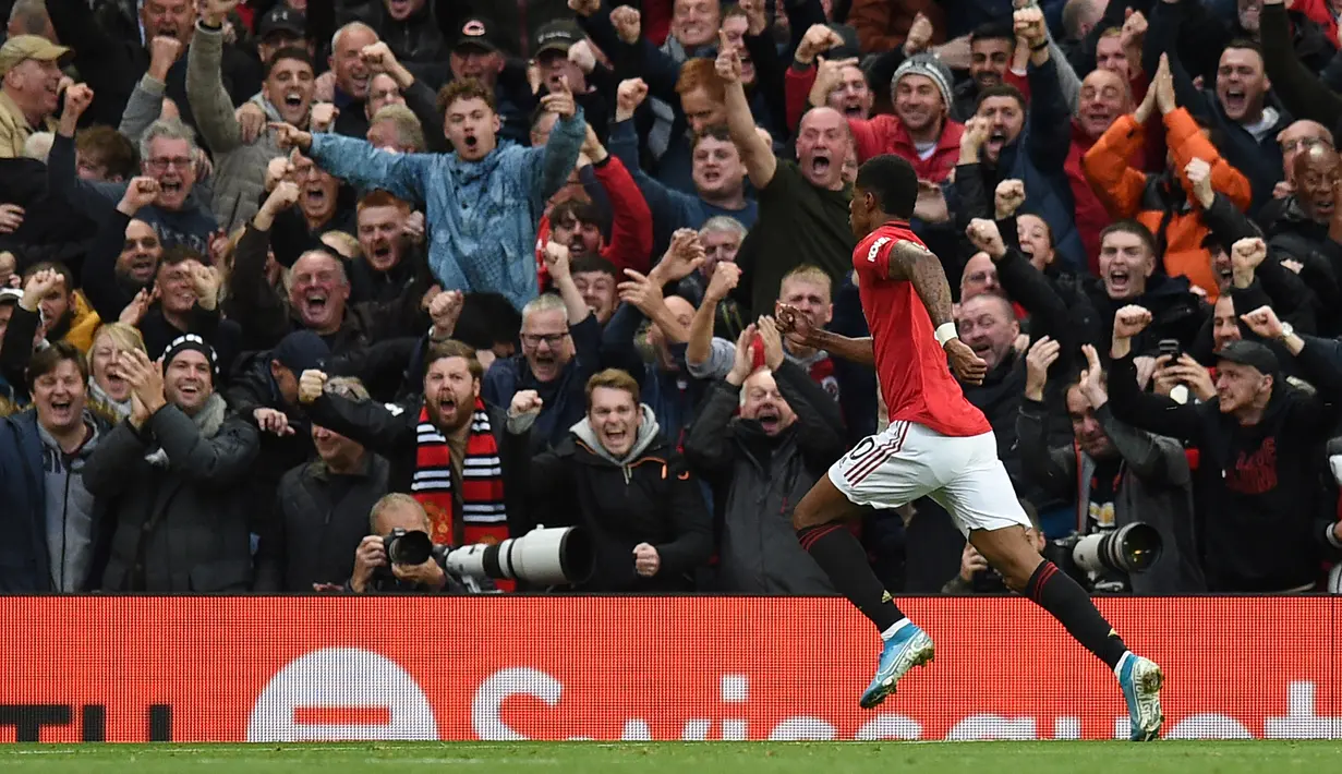 Striker Manchester United (MU) Marcus Rashford melakukan selebrasi usai mencetak gol ke gawang Liverpool pada pertandingan Liga Inggris di Stadion Old Trafford, Manchester, Inggris, Minggu (20/10/2019). Pertandingan berakhir dengan skor 1-1. (Oli SCARFF/AFP)