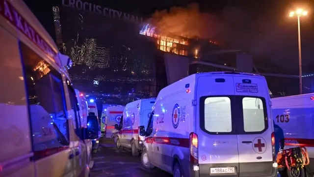 Ambulans parkir di dekat gedung Balai Kota Crocus yang terbakar di tepi barat Moskow, Rusia, Jumat, (22/3/2024).