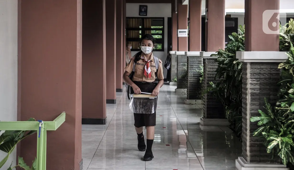 Seorang siswa mengenakan masker saat hari pertama uji coba pembelajaran tatap muka di SDN Pulogadung 07, Jakarta, Rabu (7/4/2021). Pembelajaran tatap muka di DKI Jakarta dilakukan dengan menerapkan jam belajar dari pukul 7.30 WIB - 10.30 WIB. (merdeka.com/Iqbal S. Nugroho)