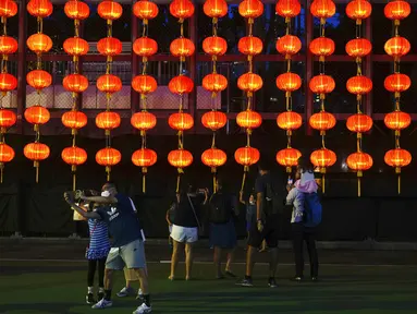 Orang-orang foto di depan dekorasi selama Festival Pertengahan Musim Gugur di taman Victoria di Hong Kong, Selasa (21/9/2021).  Festival ini jatuh pada hari ke-15 bulan ke-8 penanggalan Imlek. (AP Photo/Vincent Yu)