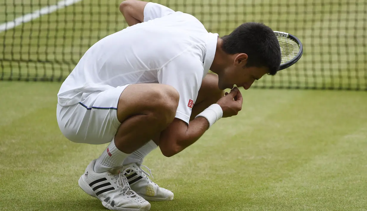 Novak Djokovic mengambil rumput lapangan dan memakannya menjadi ritual baginya bila meraih gelar Wimbledon. (EPA/FACUNDO ARRIZABALAGA)