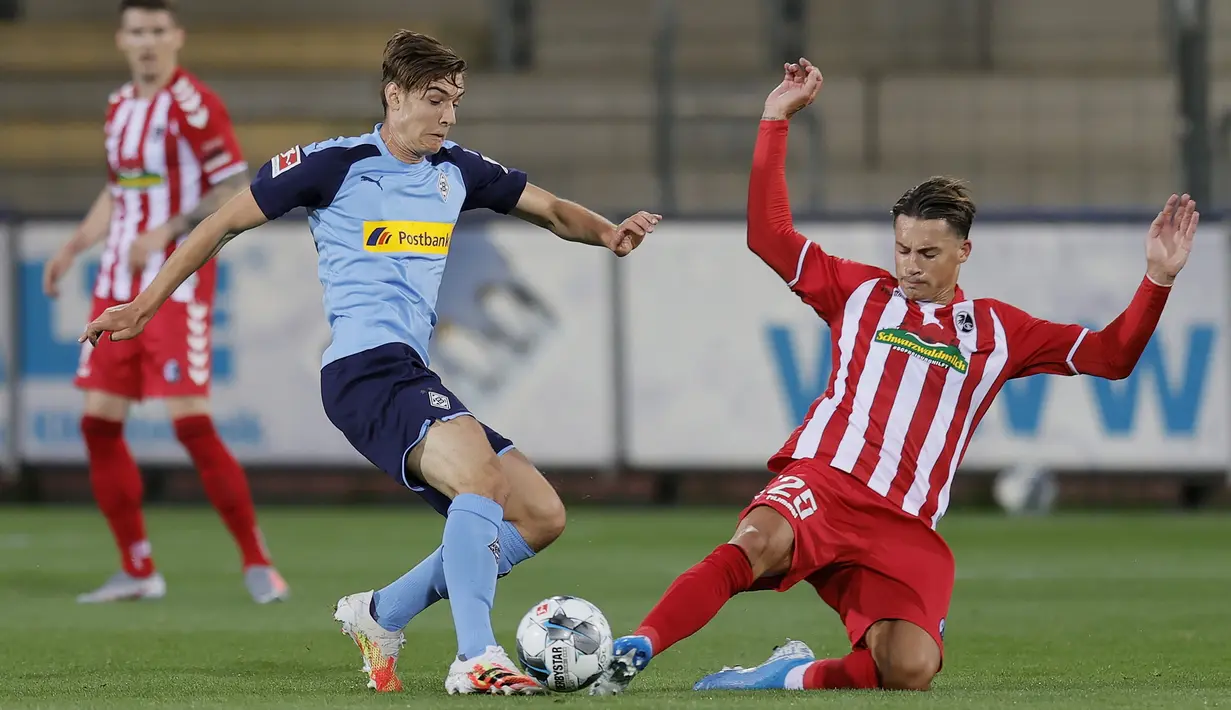 Gelandang Borussia Monchengladbach, Florian Neuhaus, berebut bola bek SC Freiburg, Robin Koch, pada laga lanjutan Bundesliga di Freiburg, Jumat (5/6/2020) waktu setempat. Monchengladbach kalah 0-1 atas Freiburg. (AFP/Ronald Wittek/Pool)