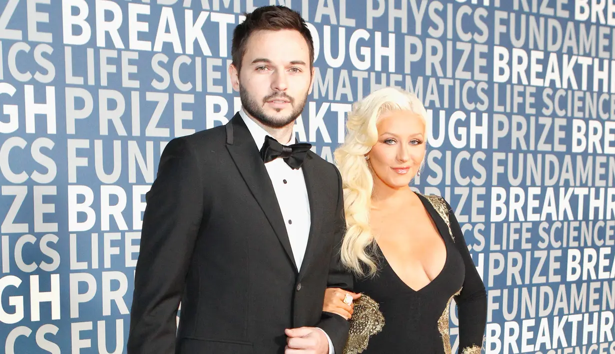 Penyanyi Christina Aguilera berpose dengan Matthew Rutler saat menghadiri Breakthrough Prize Ceremony 2016 di California, Amerika Serikat, (8/11/2015).  Penyanyi 34 tahun ini mengenakan gaun hitam dengan memperlihatkan belahan dada.  (AFP/ Kimberly Putih)