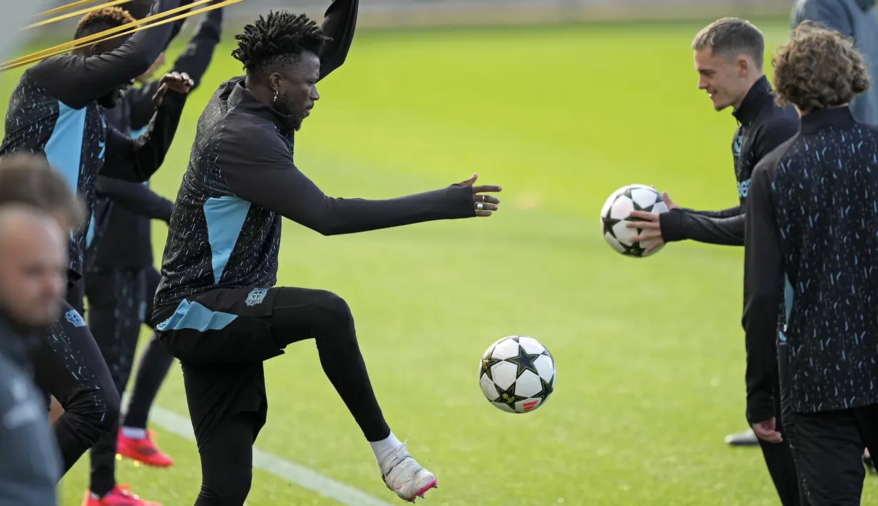 Pemain Bayer Leverkusen, Edmond Tapsoba, menendang bola saat sesi latihan jelang laga melawan AC Milan pada laga Liga Champions. (AP Photo/Martin Meissner)