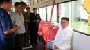 Pemimpin Korea Utara Kim Jong-Un tersenyum saat duduk di dalam bus jenis baru yang diproduksi selama kunjungan ke pabrik bus di Pyongyang, (4/8). (AFP Photo/KCNA)