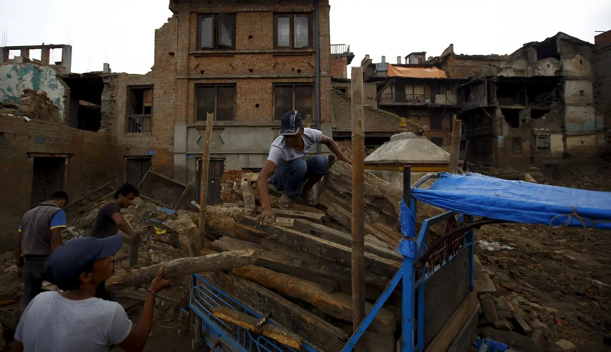 Sejumlah Warga mengumpulkan puing-puing bangunan yang rusak akibat gempa di Bhaktapur, Nepal (14/7/2015). PBB melaporkan dua bulan setelah gempa di Nepal, warga masih sulit mendapatkan makanan dan perawatan kesehatan. (REUTERS/Navesh Chitrakar)