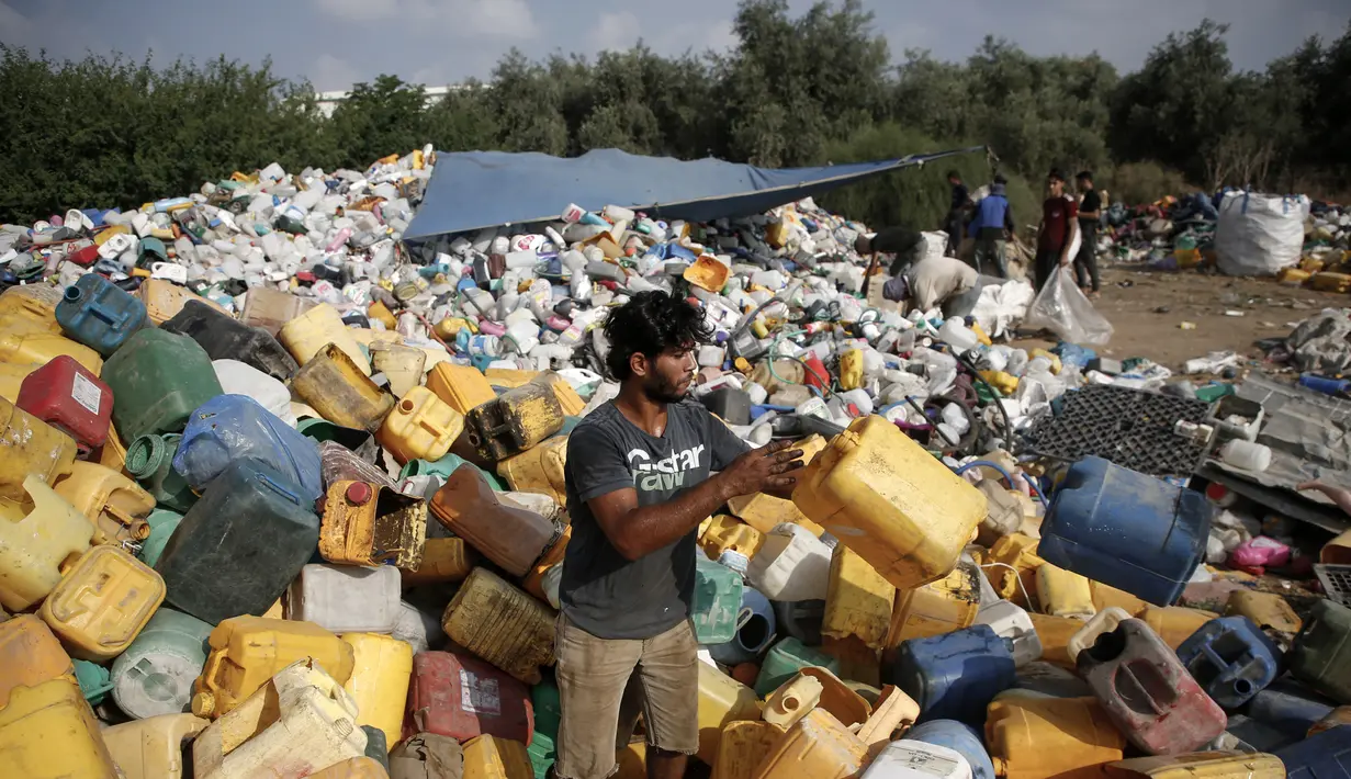 Pengumpul sampah Palestina menimbun jerigen sambil memilah-milah sampah di tempat pembuangan sampah di Gaza (29/7/2019). Kemiskinan yang terjadi akibat blokade Israel dan kurangnya kesempatan kerja membuat beberapa warga Palestina memilih bekerja mencari sampah untuk dijual. (AFP Photo/Mohammed)