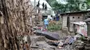 Warga berjalan di dekat tanggul batang pohon yang berada di bantaran Kali Ciliwung, Rawajati, Jakarta, Minggu (5/1/2020). Tanggul dari kayu dolken dan karung pasir yang baru dibangun pada akhir Desember 2019 itu rusak hingga dipenuhi sampah akibat terjangan arus banjir. (merdeka.com/Iqbal Nugroho)