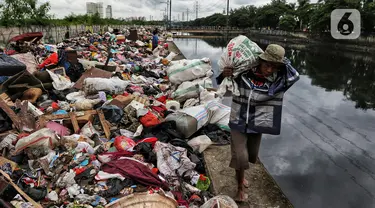 Warga membawa sampah sisa banjir yang dikumpulkan dari sepanjang Kali Cengkareng, Jakarta Barat, Kamis (9/1/2020). Tumpukan sampah di sepanjang bantaran kali dan rumah-rumah warga terlihat setelah banjir yang melanda sejumlah kawasan Jakarta mulai surut. (Liputan6.com/Johan Tallo)