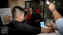 Para wartawan yang hendak mengambil gambar terlibat adu dorong dengan petugas pengamanan saat rekan pengacara dari OCK and Associate digiring masuk ke dalam Gedung KPK, Jakarta, Jumat (10/7).  (Liputan6.com/Helmi Afandi)