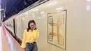 Gaya Luna Maya menjajal kereta luxury di Jepang. Ia mengenakan atasan lengan panjang berwarna kuning, dipadunya dengan celana jeans abu-abu. [Foto: Instagram/lunamaya]