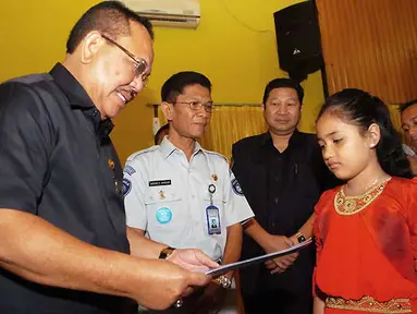 Bupati Aceh Tenggara Hasanuddin (kiri) menyerahkan santunan kepada Silviana Aisyah, ahli waris korban kecelakaan pesawat NBA Cassa 212, di Kutacane,Aceh Tenggara, Rabu (5/10). (Antarafoto)