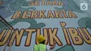 Muralis perempuan menyelesaikan pembuatan mural pada dinding di kawasan Juanda, Jakarta, Rabu (16/6/2021). Ini adalah mural ketiga di Jakarta dengan menggunakan cat Graphenstone. (merdeka.com/Imam Buhori)
