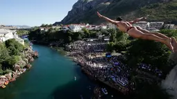 Peserta melakukan lompatan dari atas jembatan Mostar selama kompetisi menyelam tradisional ke 451 di Mostar, Bosnia, Minggu (30/7). Para peserta dari Bosnia dan negara-negara tetangga itu melakukan lompatan dari ketinggian 25 meter. (AP Photo/Amel Emric)
